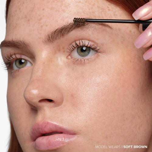 Soft Brown | Volumizing Tinted Brow Gel -Model Holding Product Wand