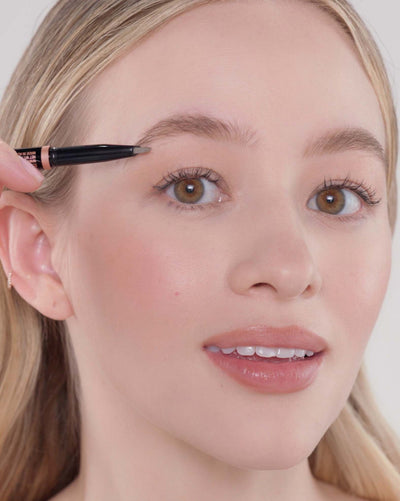 Applying Brow Definer in Taupe and Brow Freeze® Gel